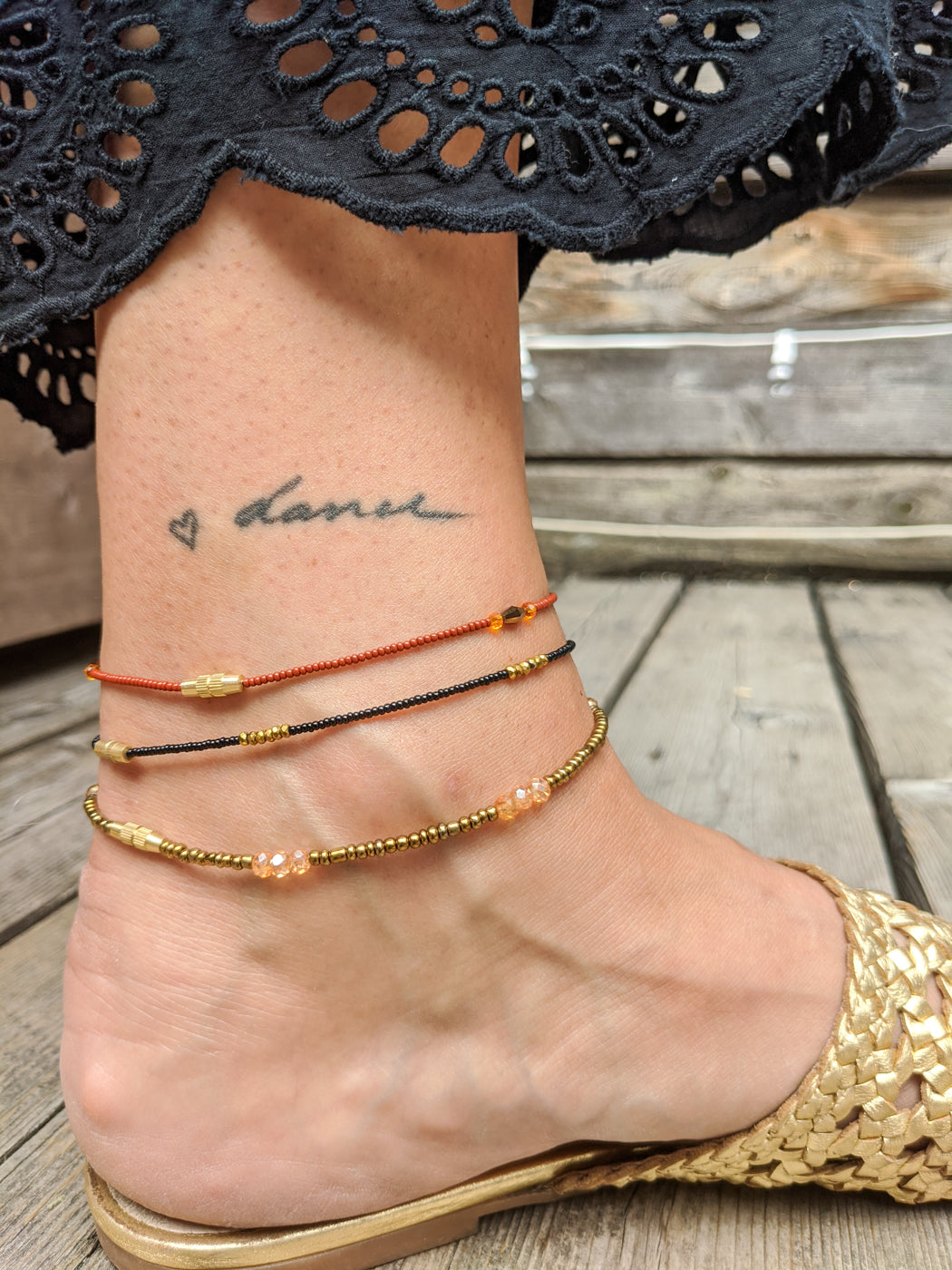 Red, Black, and Brass Anklet Stack